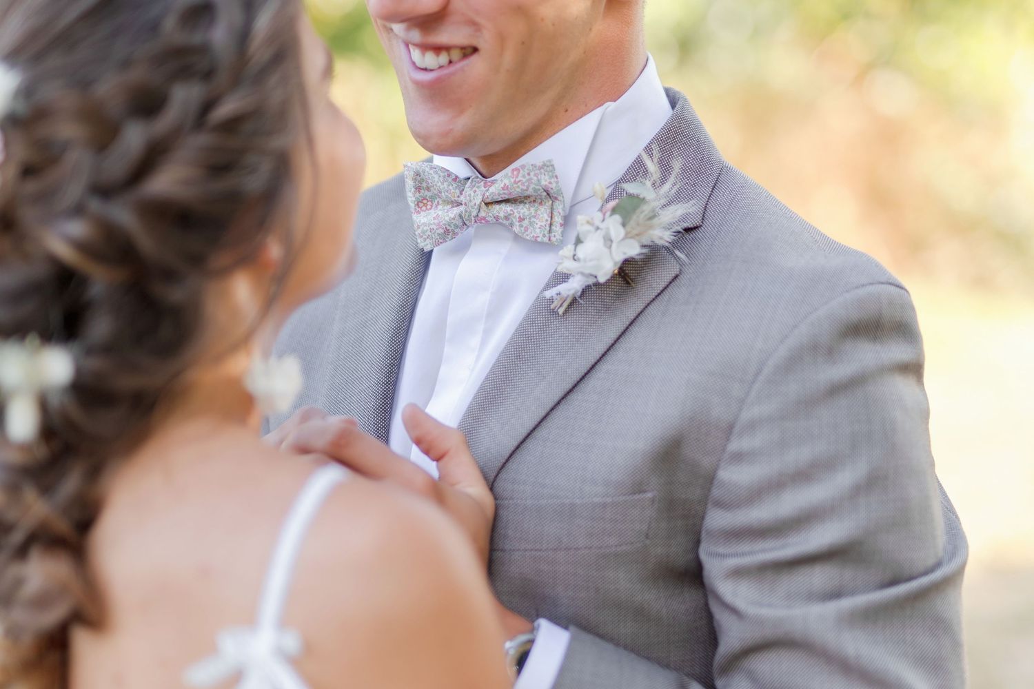 Wedding couple showing their rings in outdoor setting.