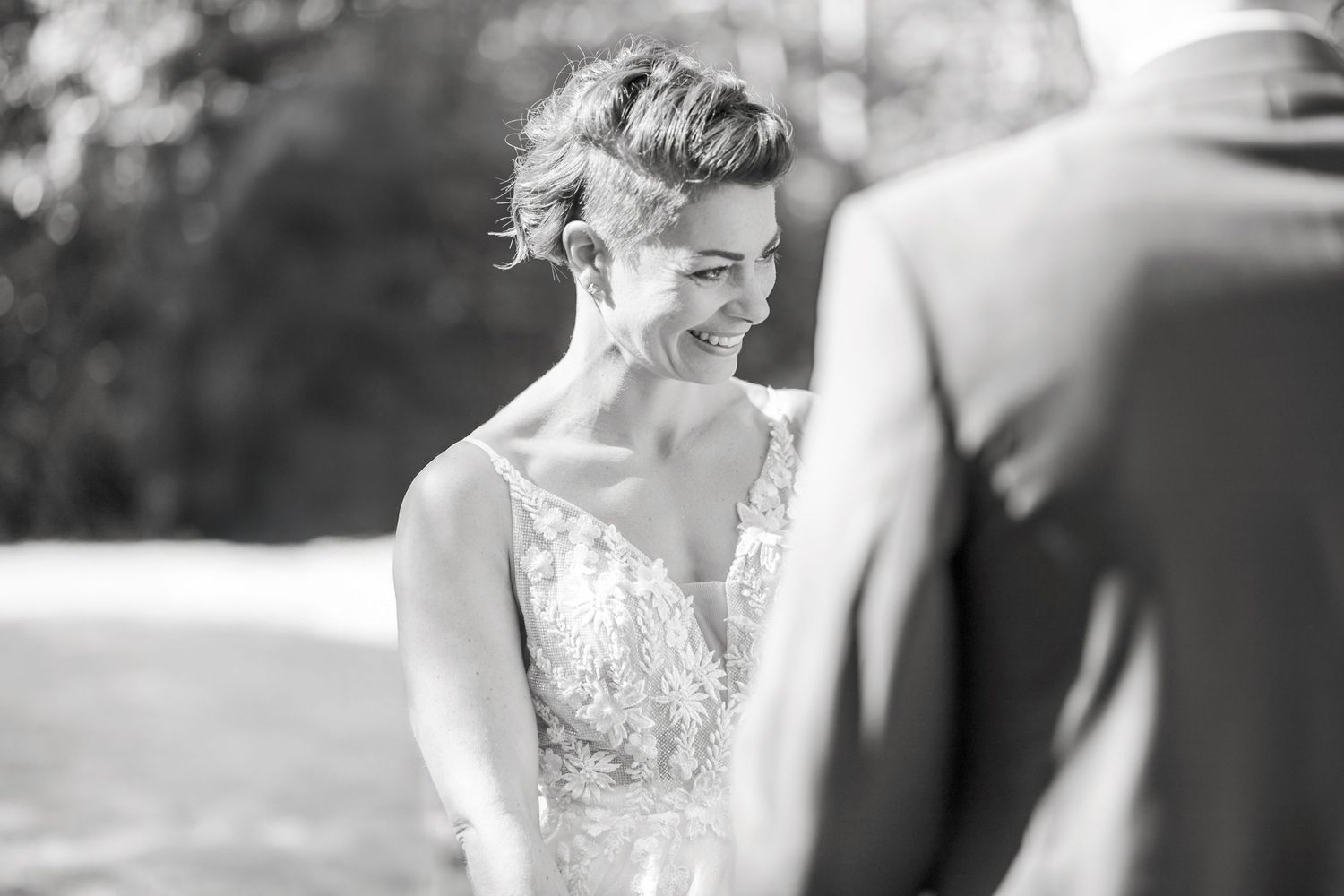 An intimate black and white wedding ceremony moment outdoors.