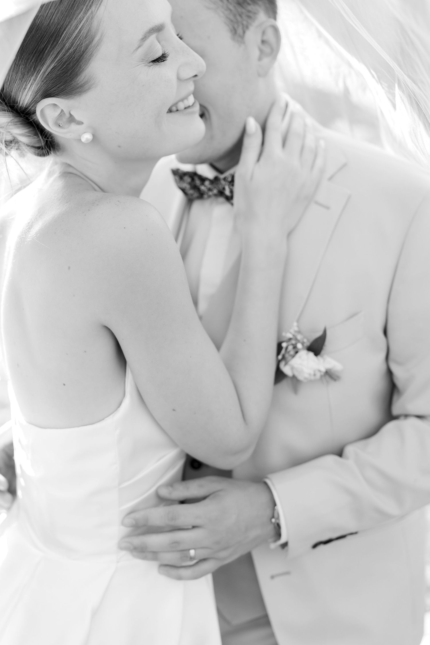 Black and white wedding portrait capturing a tender moment between newlyweds.