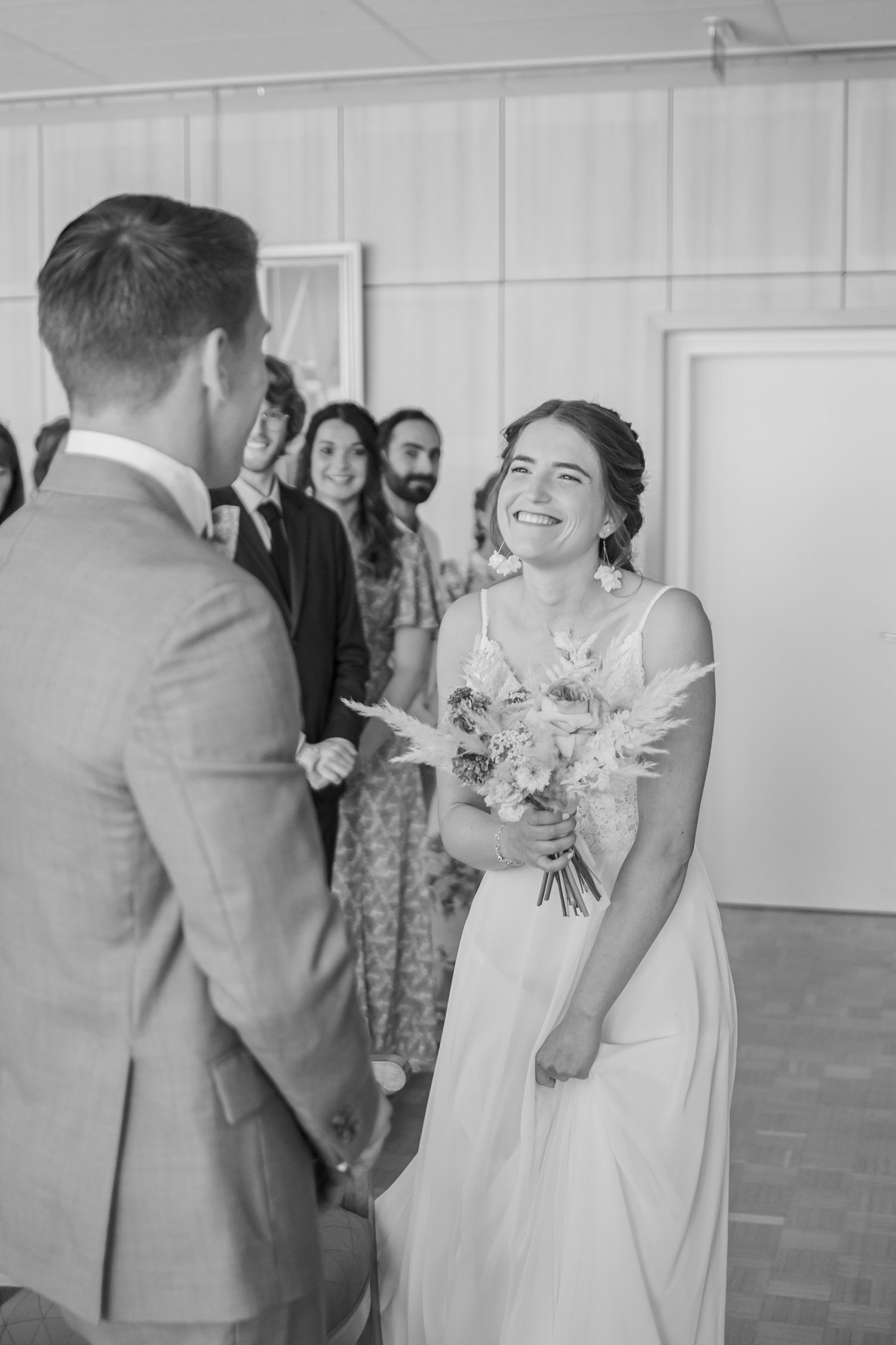Wedding celebration moment captured in black and white indoors with natural light.