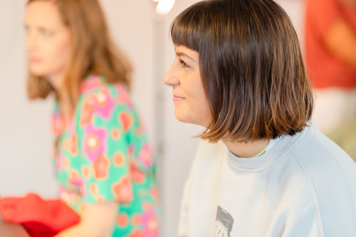 Side profile of person with short bob haircut in casual indoor setting.