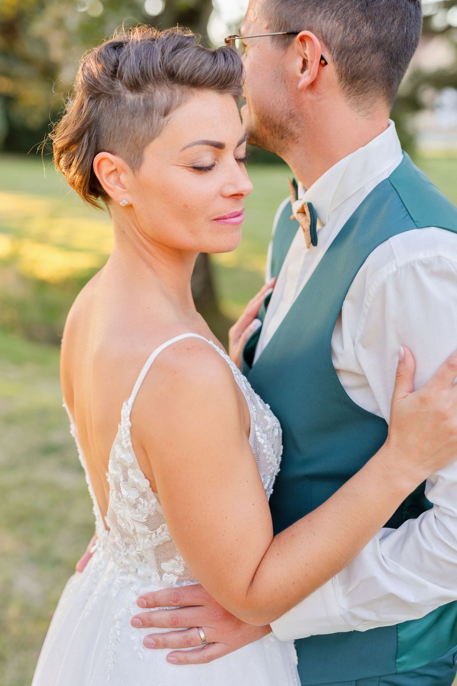 Intimate wedding portrait showing couple in close embrace with bride wearing delicate lace gown.