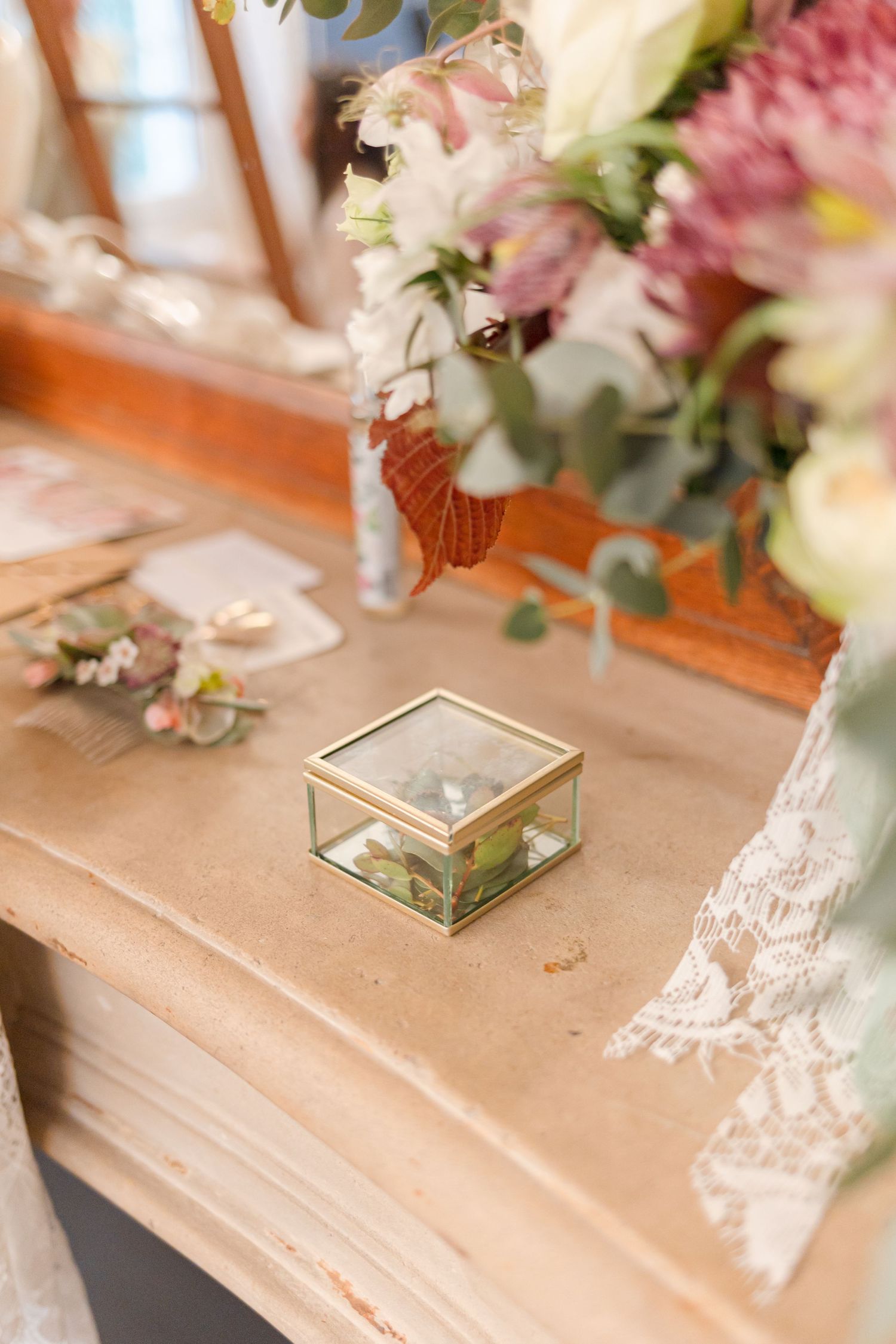 Wedding table decorations featuring floral arrangements and gold glass terrariums.