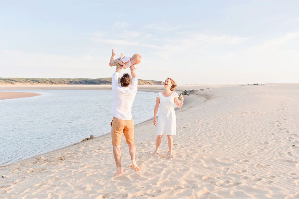 Candid family moments captured on sunny beach with soft lighting.