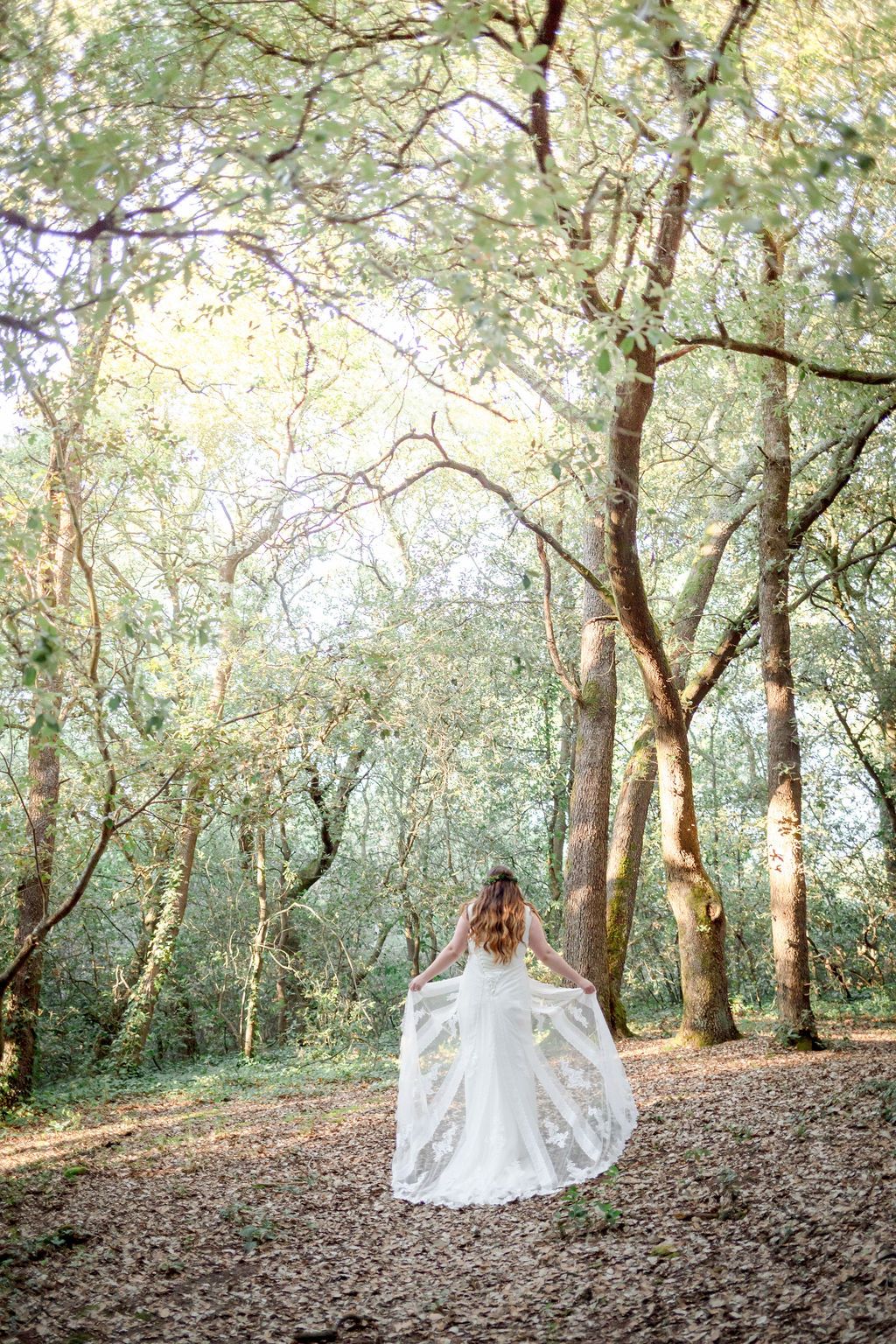 A series of romantic forest photos showing a flowing white wedding dress against sunlit trees and fallen leaves.