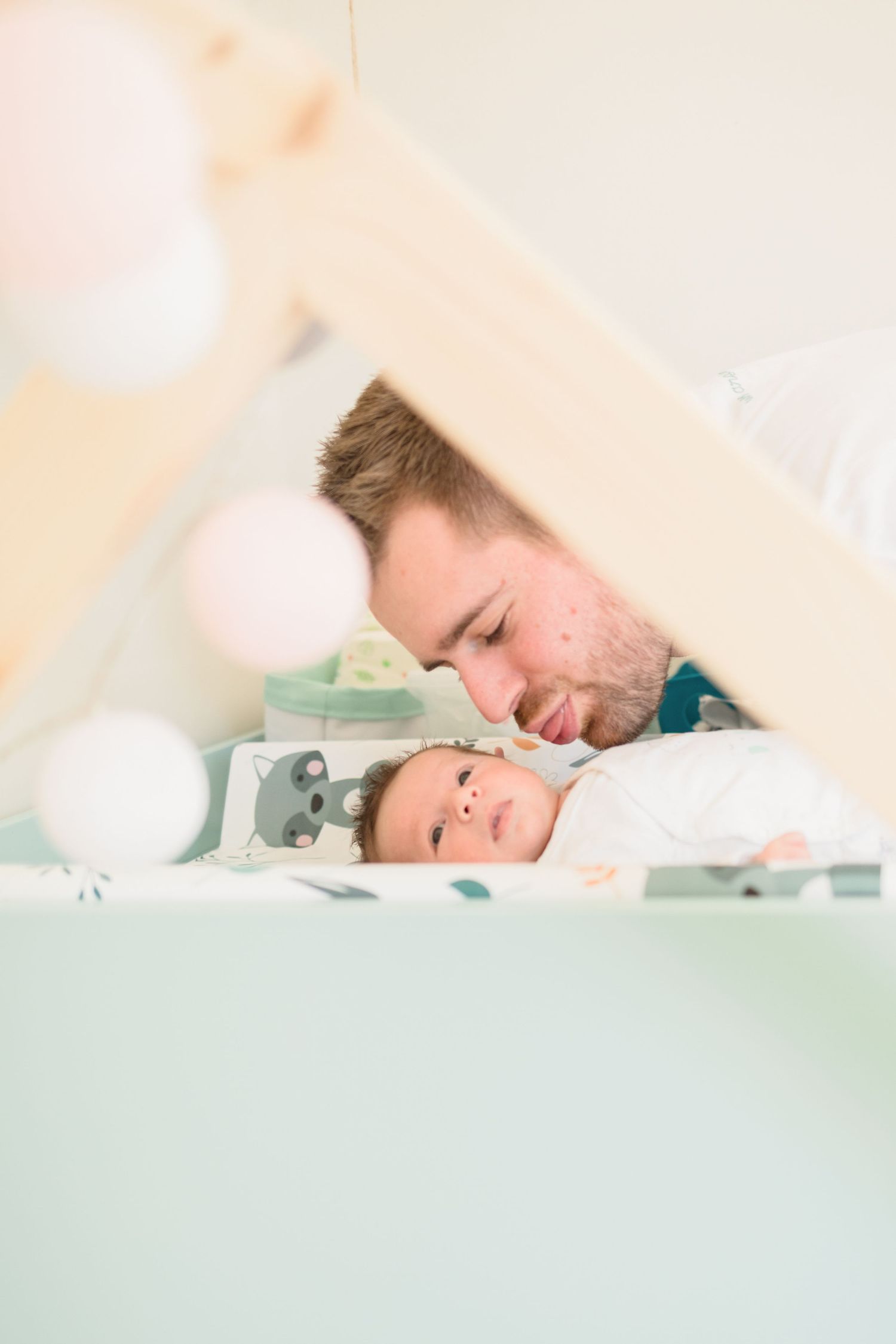 Tender moment between parent and baby in contemporary nursery setting.
