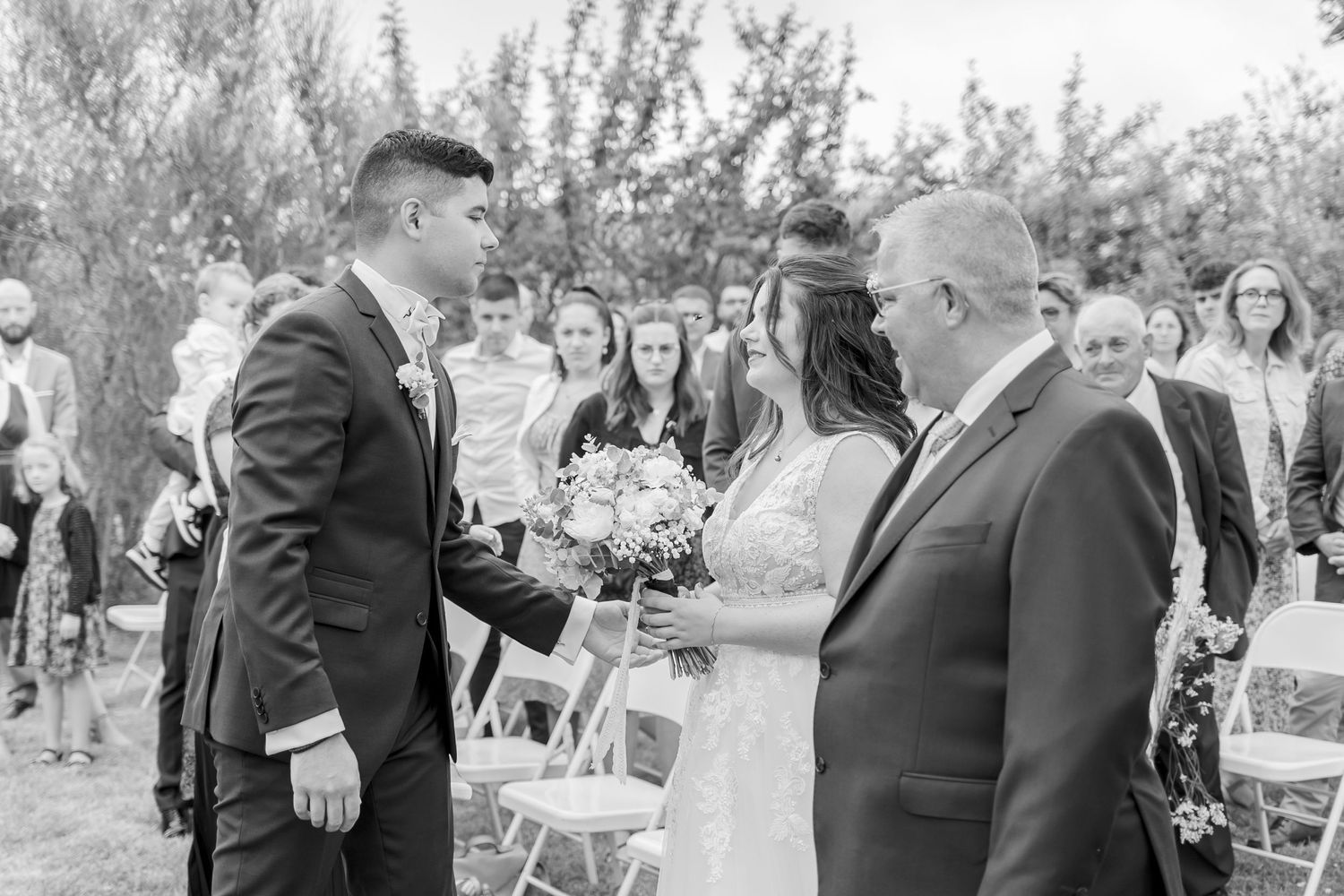 Black and white photos of wedding guests mingling at an outdoor reception.