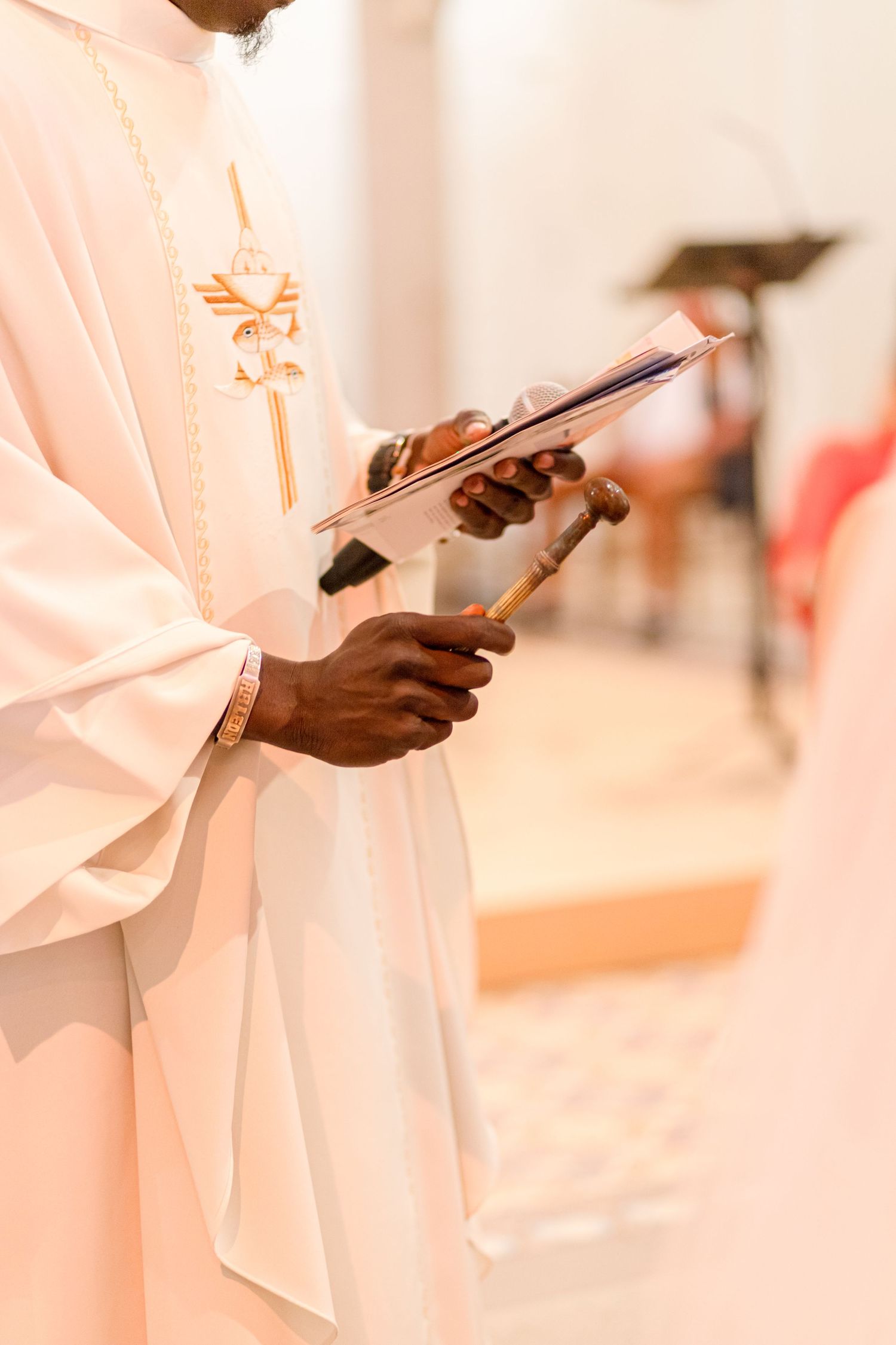 Close-up of clergy member holding a book during religious ceremony.