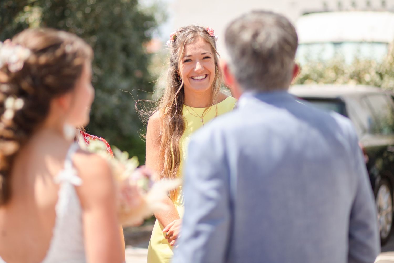 Wedding guests mingling outdoors during a sunny celebration.