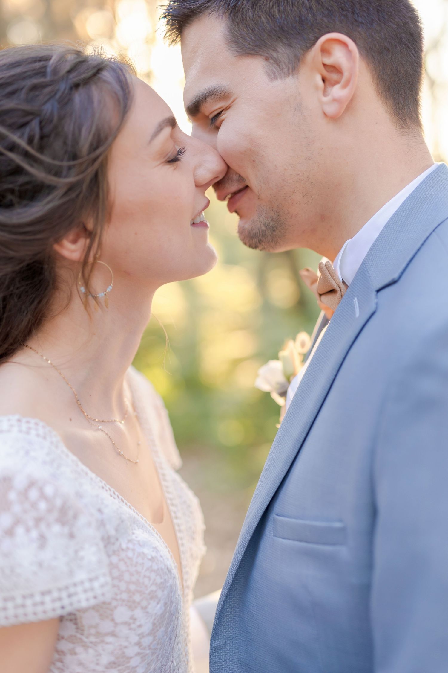 Intimate close-up of a romantic wedding moment captured in golden sunlight.