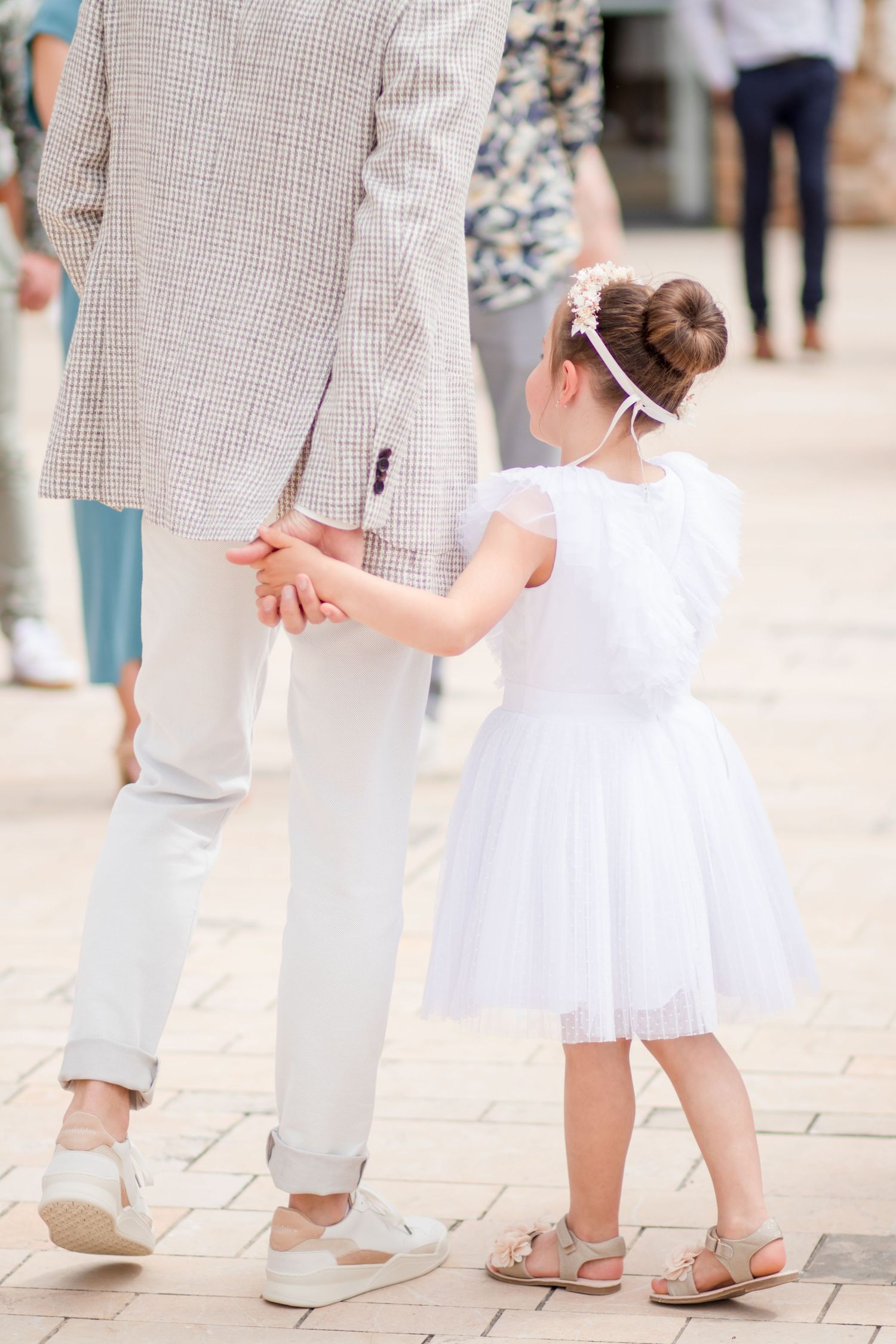 Lower body shot of formal attire with white dress and checkered suit at event.