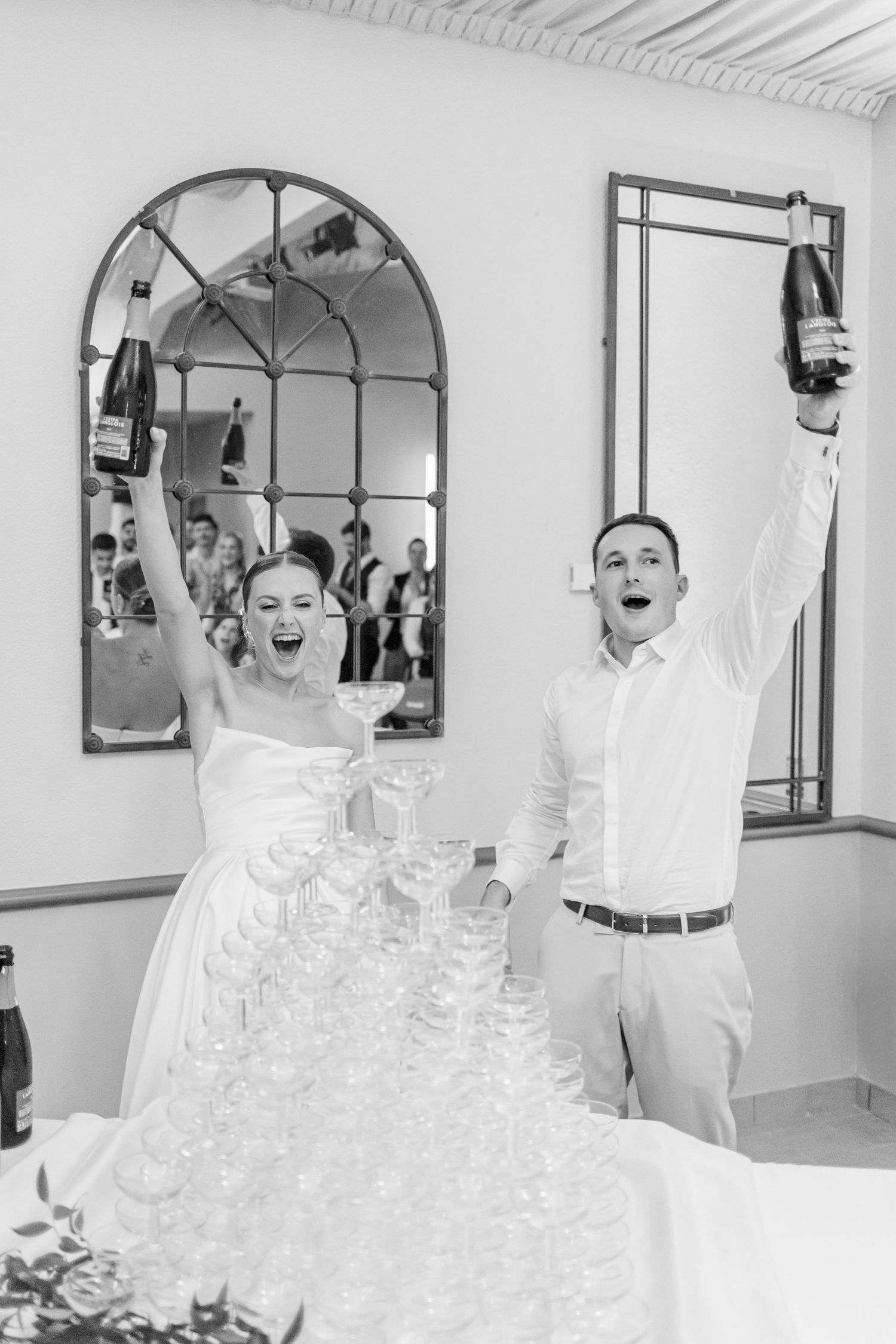 Champagne tower being poured at an elegant wedding reception.