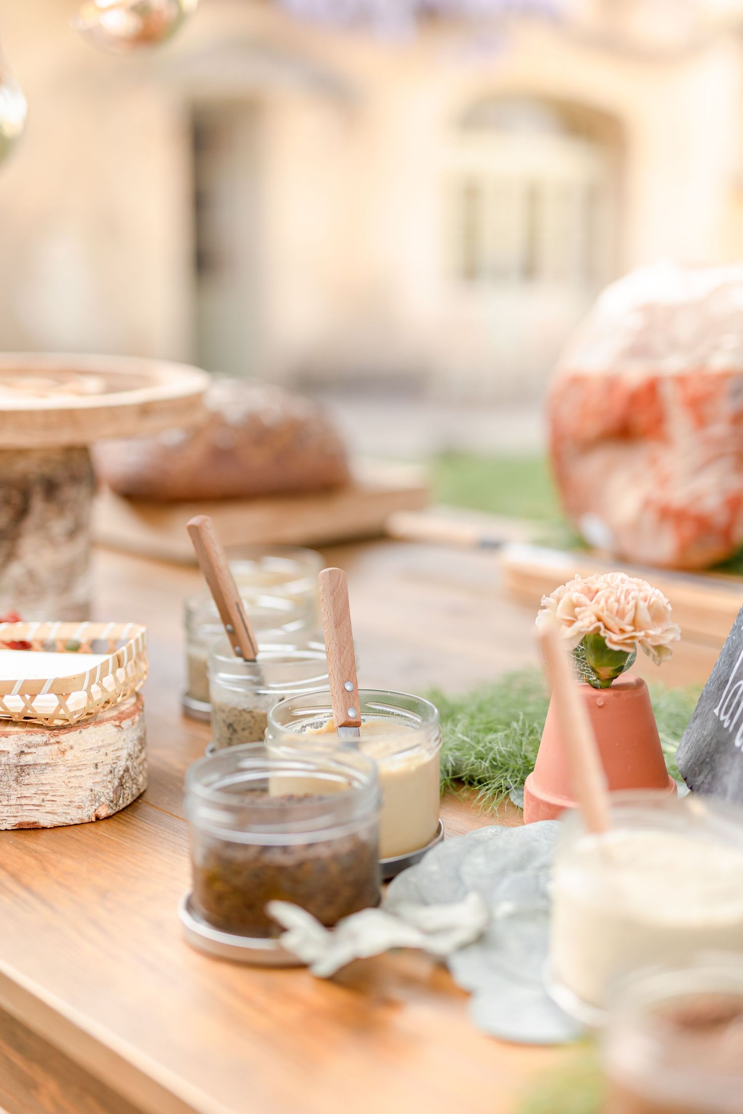 Elegant table setup with glass jars and coral-colored accents for a wedding reception.