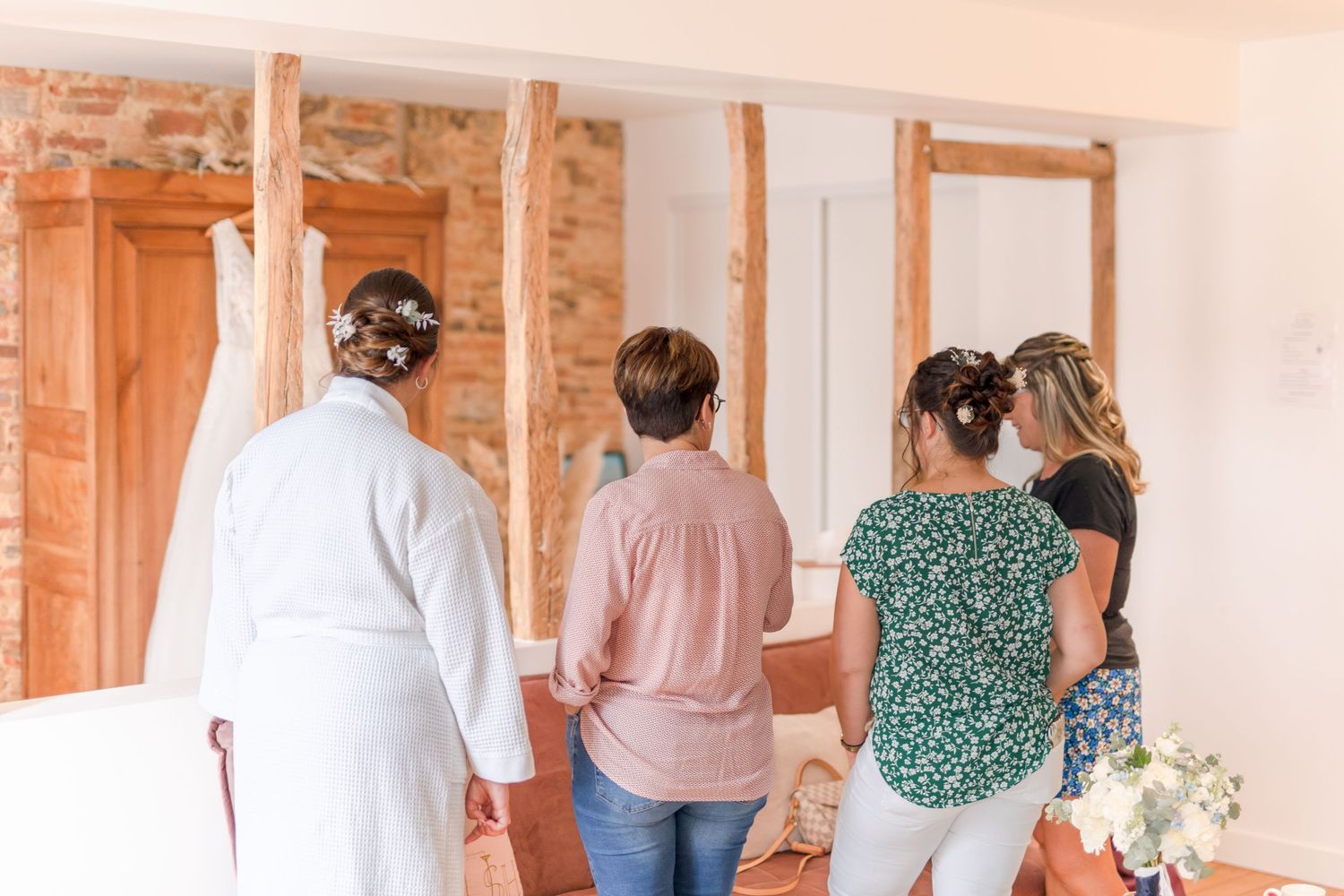 A group stands in a room with exposed brick walls during event preparations.