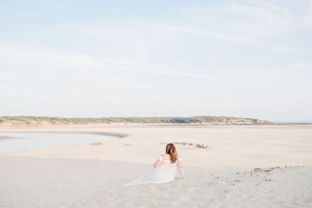 Family dressed in white enjoying a dreamy sunset beach photoshoot in soft neutral tones.