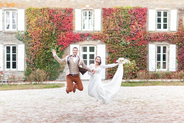 Wedding celebration with people jumping in front of a historic building with red ivy.