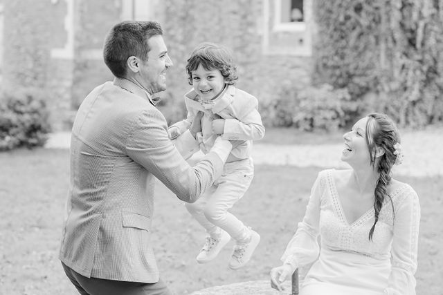 A joyful black and white family moment captured in a garden setting.