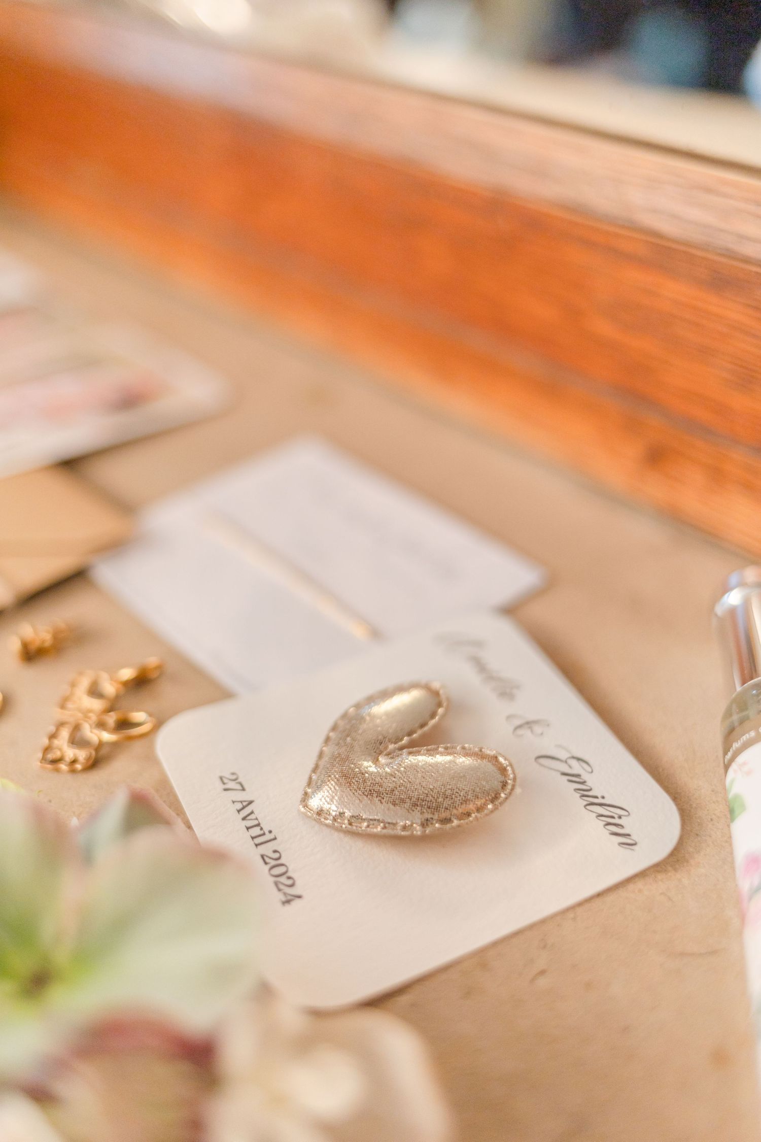 Close-up of a golden heart decoration on white paper with wooden surface.