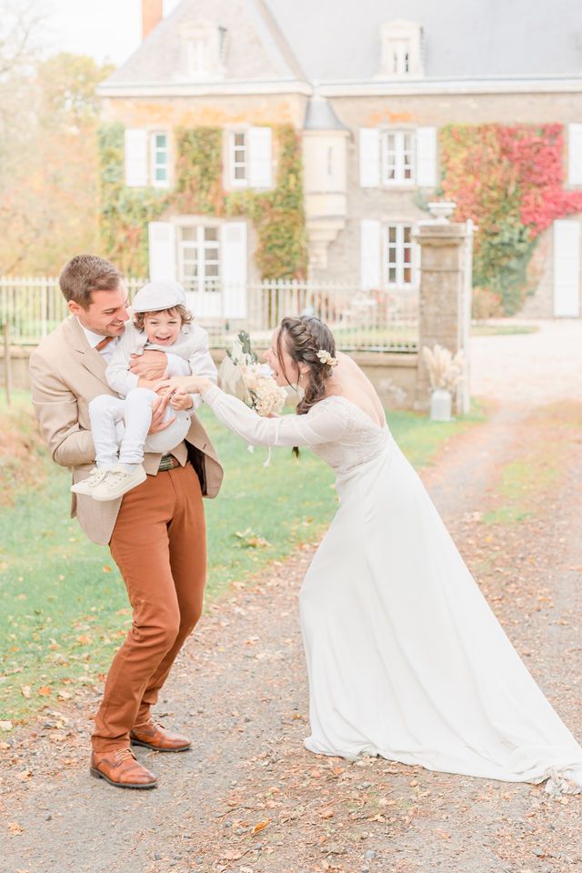 Playful autumn wedding photos on a leaf-covered path.