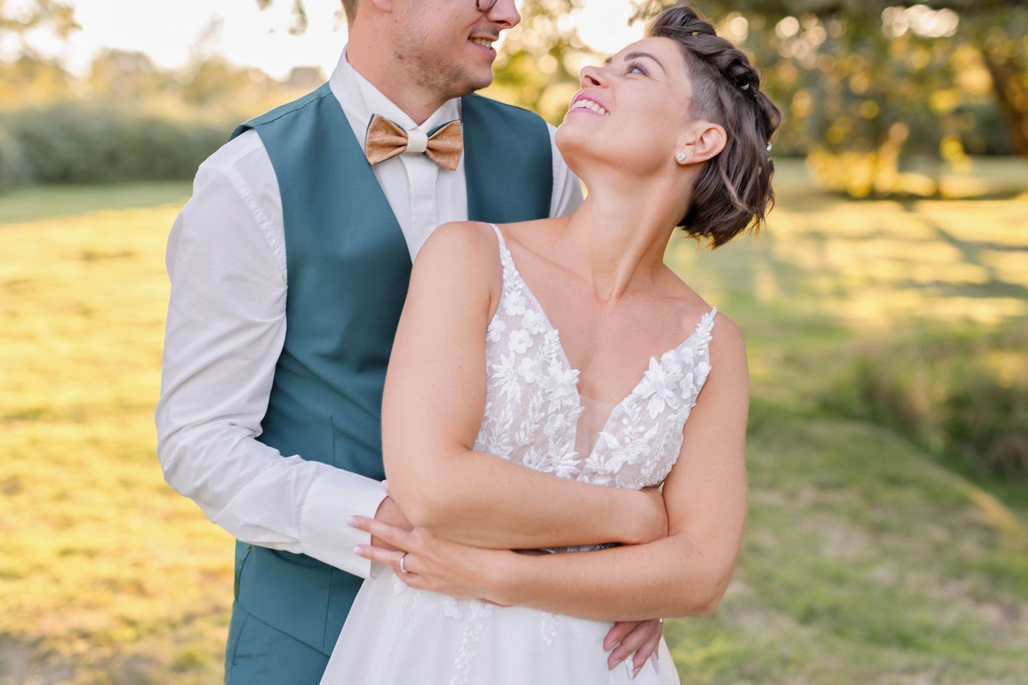 Candid moment between couple in wedding attire during golden hour.