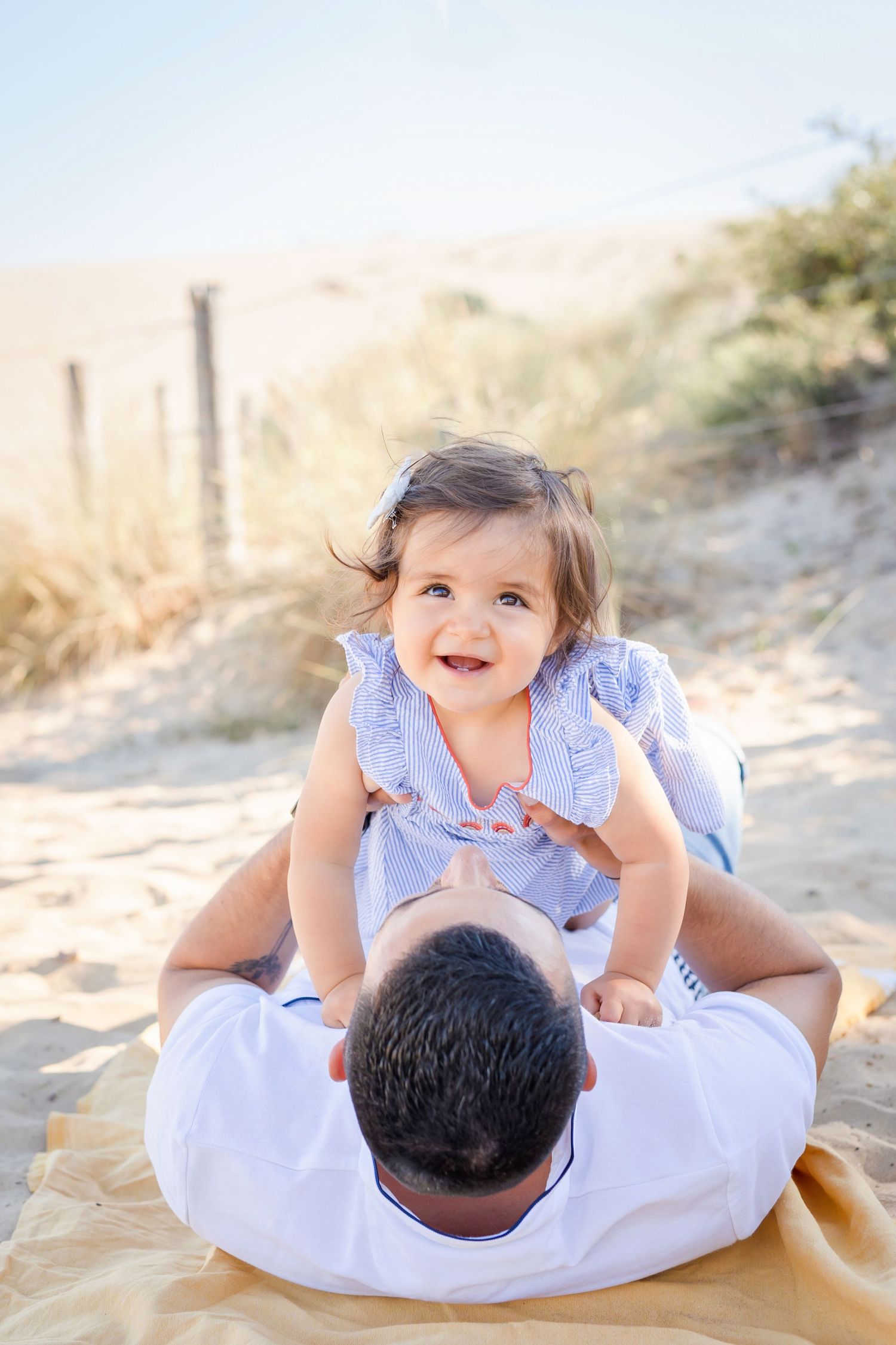 Sweet family moment captured on the beach with children playing.