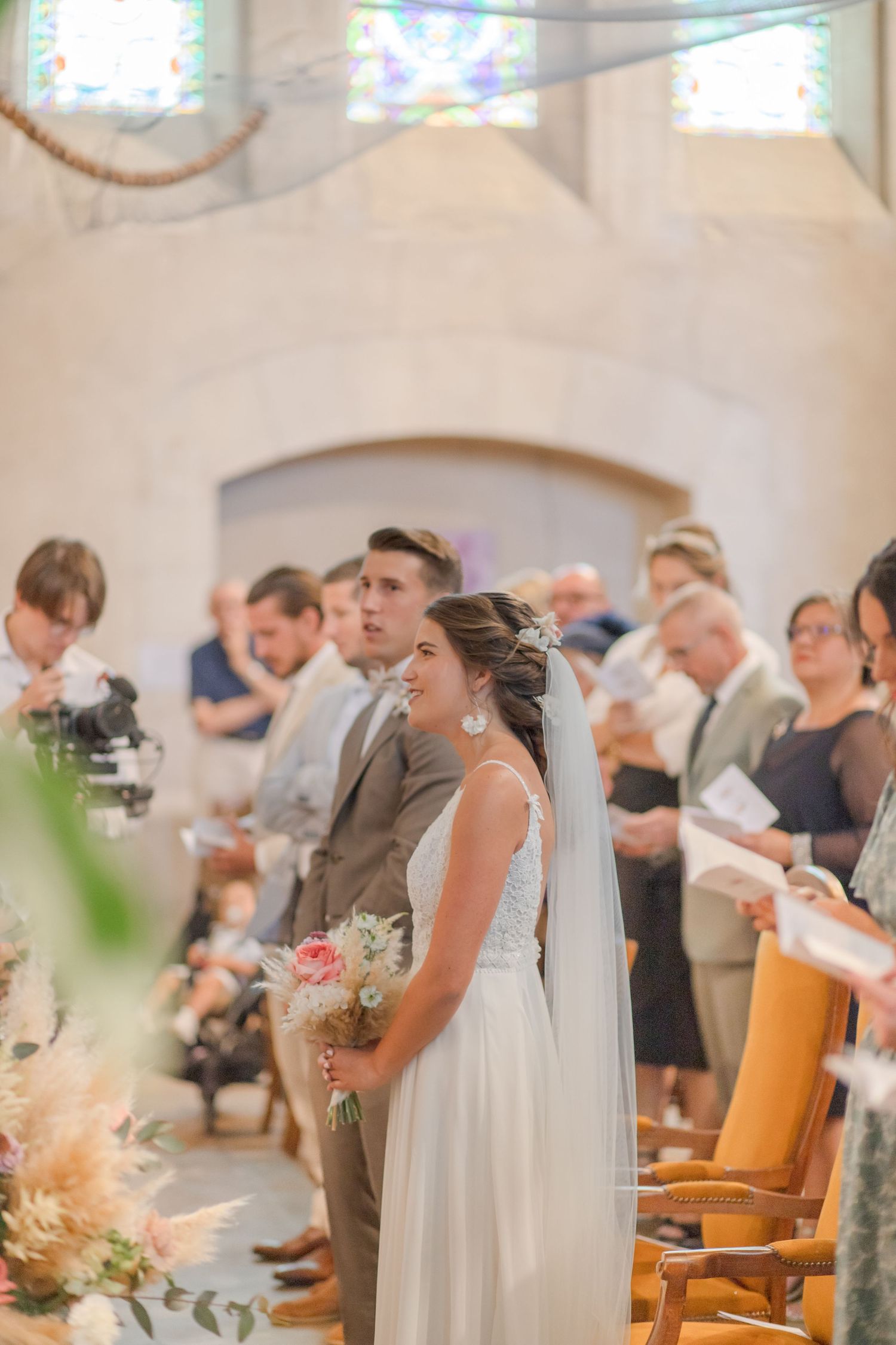 Wedding ceremony attendees standing in a traditional church sanctuary.