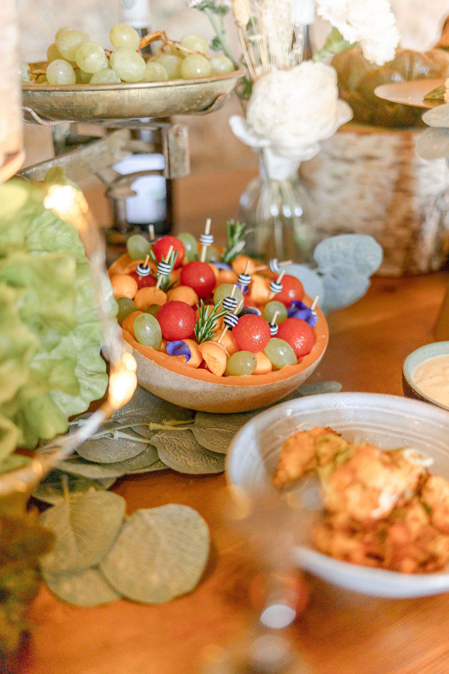 Fresh colorful appetizer spread featuring bright tomatoes and various dishes on rustic wooden table.