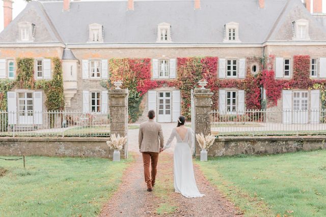 Couple walking away from historic mansion with red ivy covered walls.