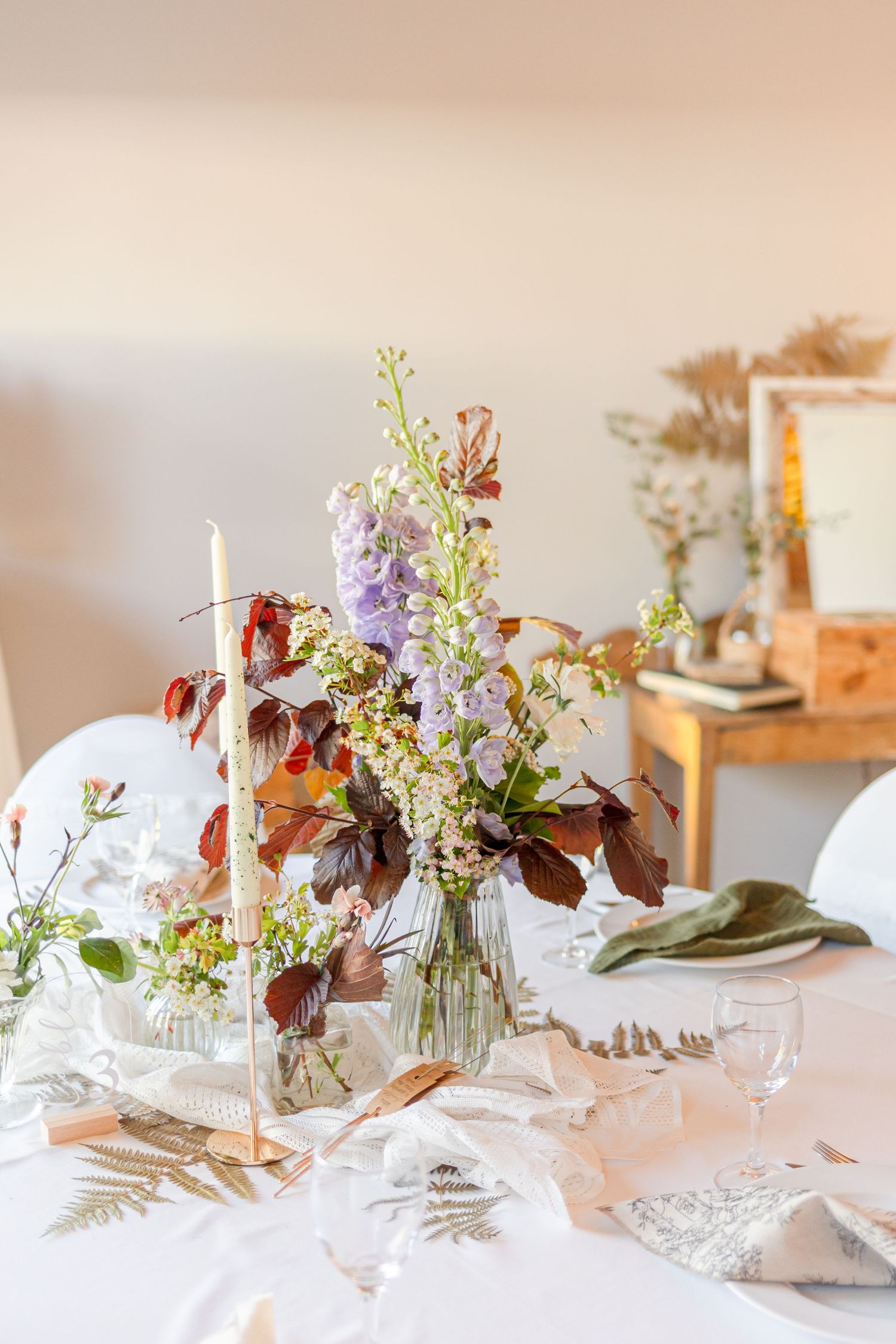 Elegant table settings with wildflower centerpieces and place settings in soft natural light.