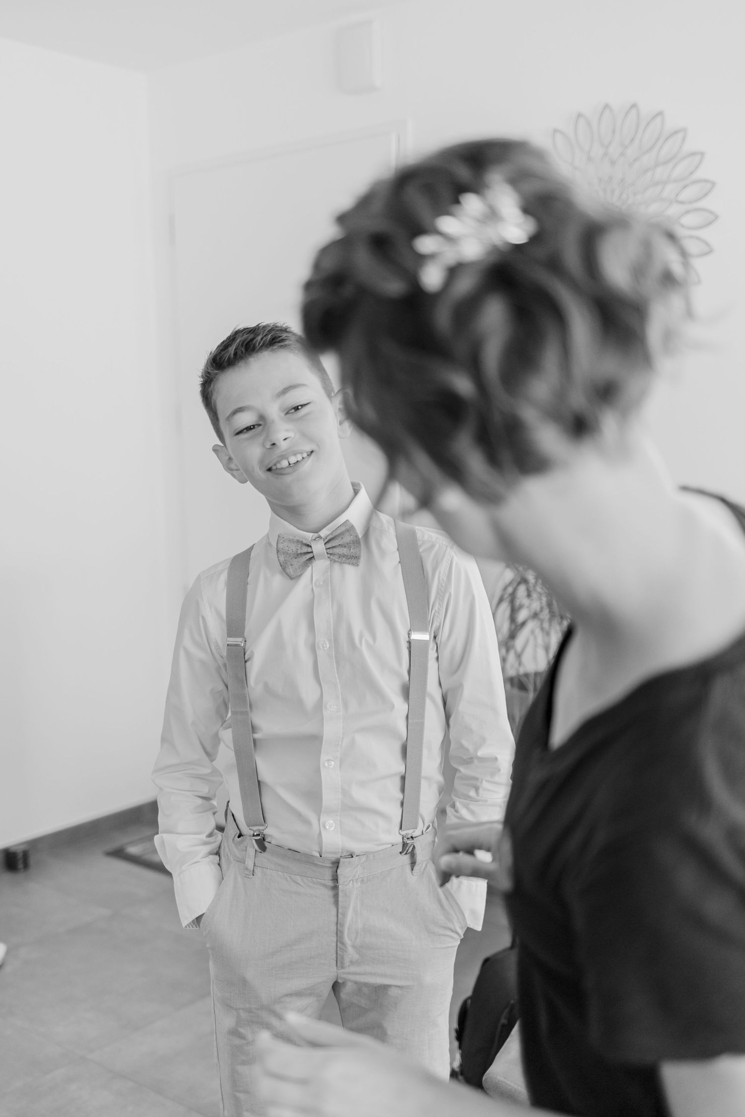 A candid moment of preparation with formal wear including suspenders and bow tie.