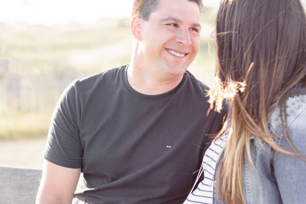 Joyful moment captured between couple during sunset maternity photoshoot.