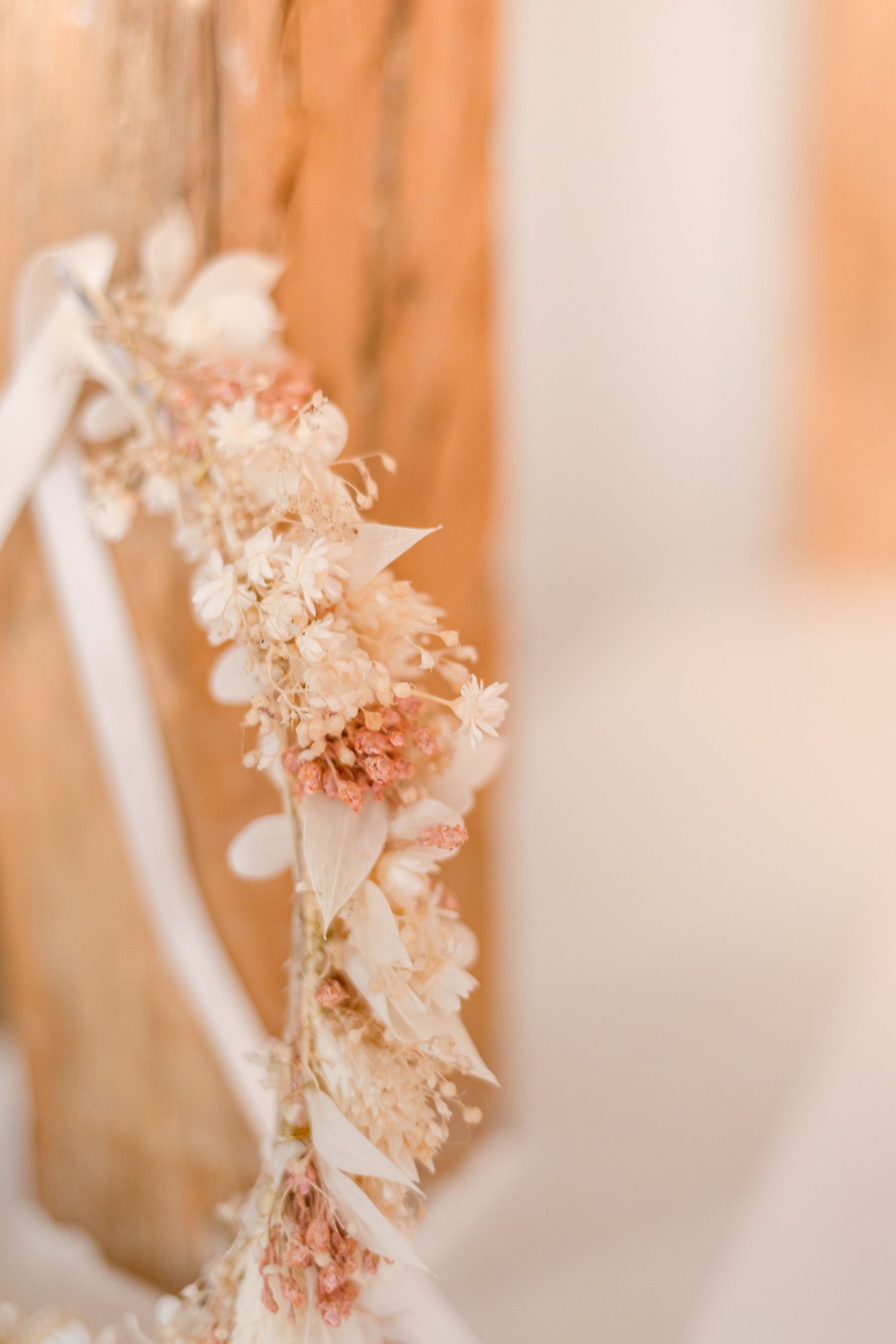 Close-up of dried floral crown showing intricate peach and cream colored details.