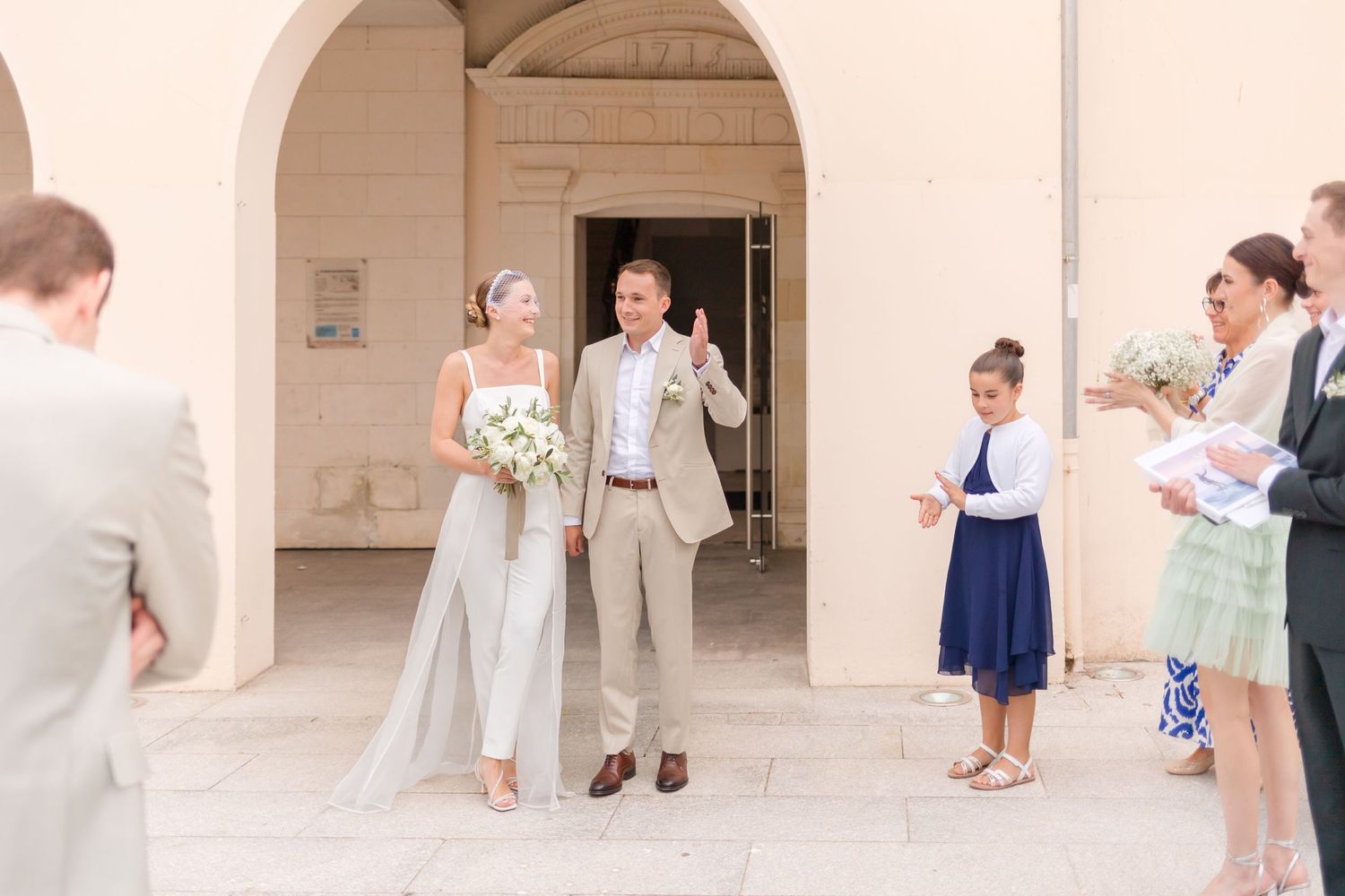 Wedding party gathered under an archway entrance celebrating the special moment.