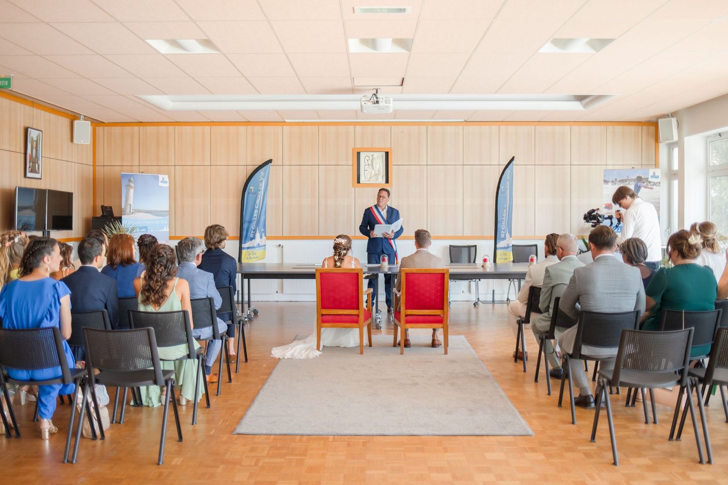 Large meeting room setup with chairs arranged in rows and natural lighting.