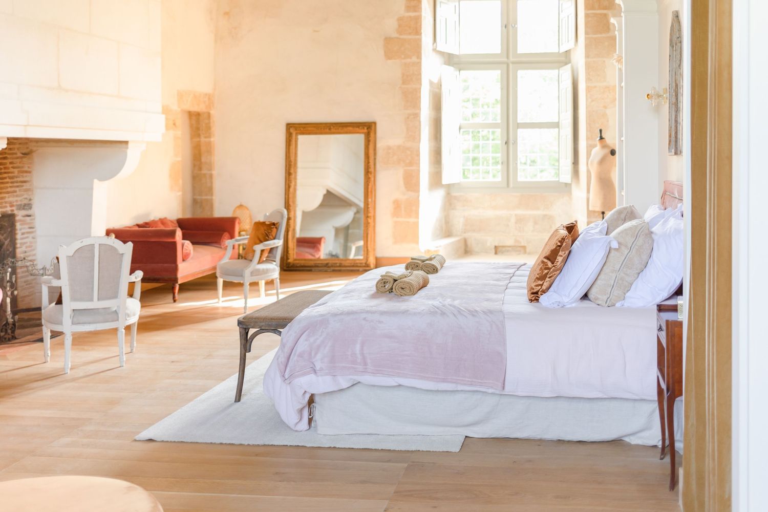 Sun-filled bedroom interior with white linens and natural wood ceiling.