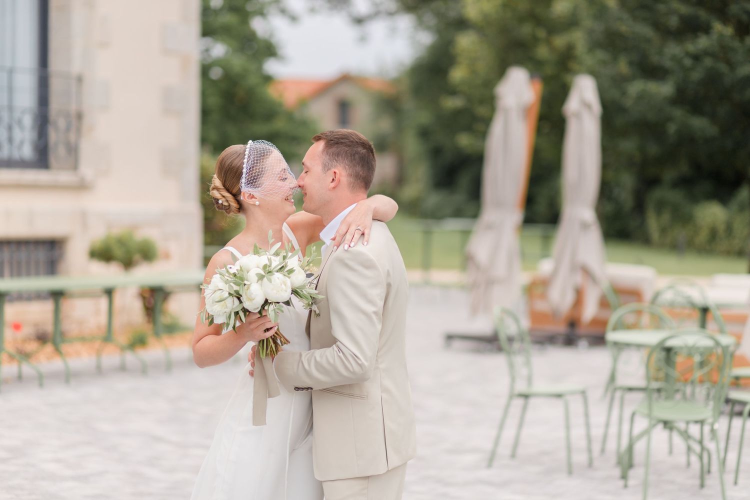 Bridal party walking along a charming European street with stone buildings and palm trees.