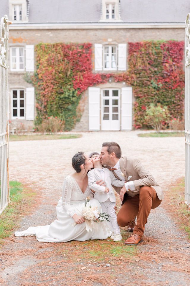 Tender family moment captured through iron gates at a historic French estate.