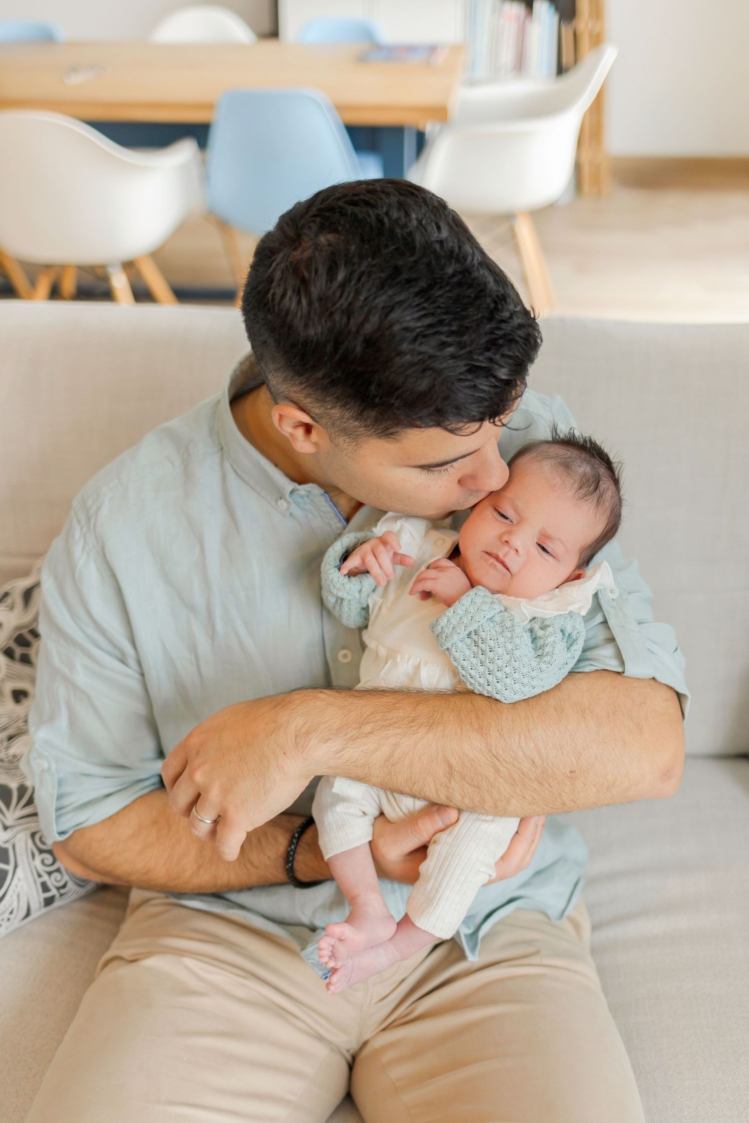 Close-up photo of parent cradling a newborn baby wrapped in soft blankets.