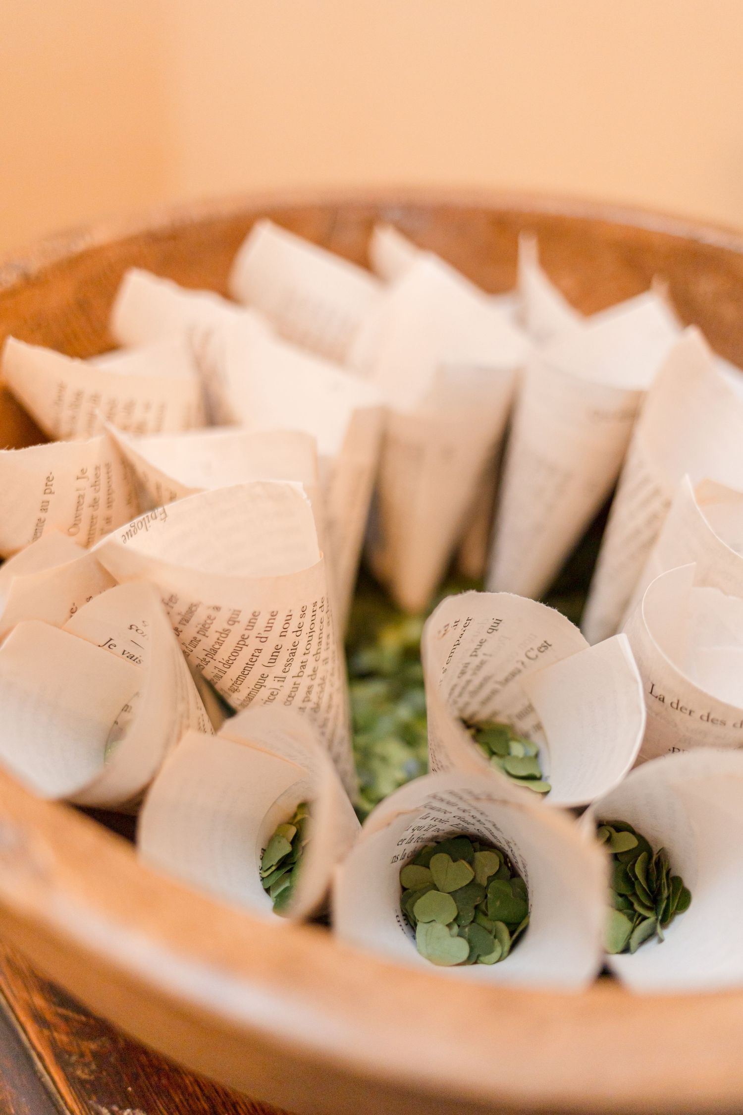 Decorative paper cones filled with confetti or petals arranged in a wooden bowl.