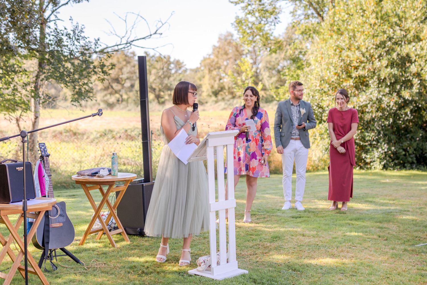 Wedding ceremony in progress with musicians and decorative white pillars.