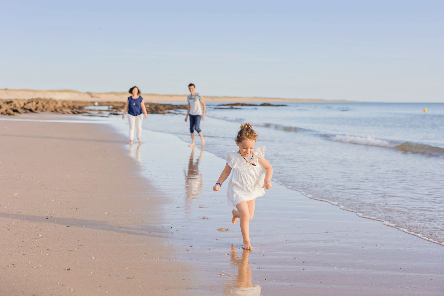 Running and playing along the shoreline on a peaceful beach day.