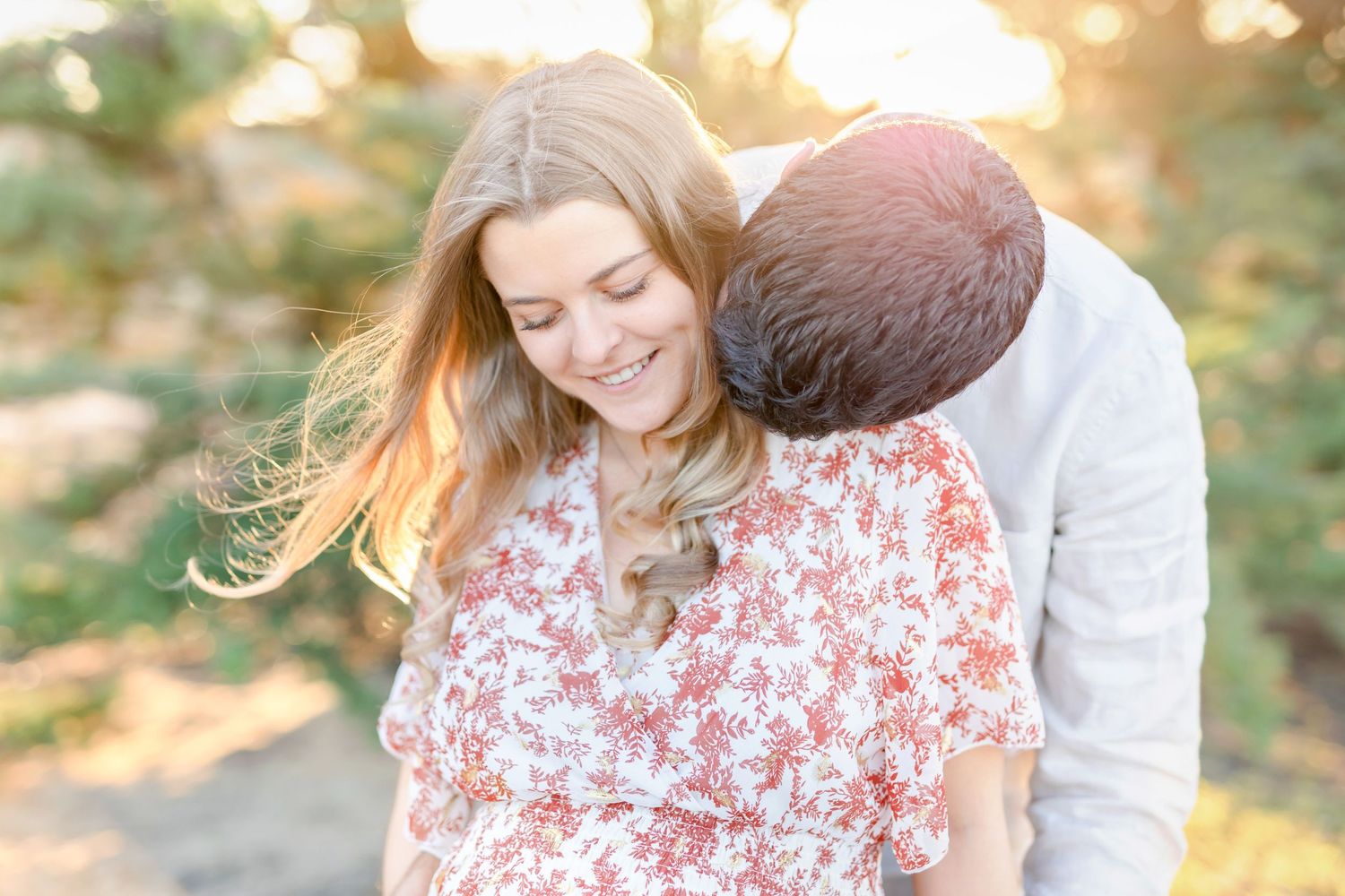 Romantic sunset portrait with a floral dress and soft embraces.