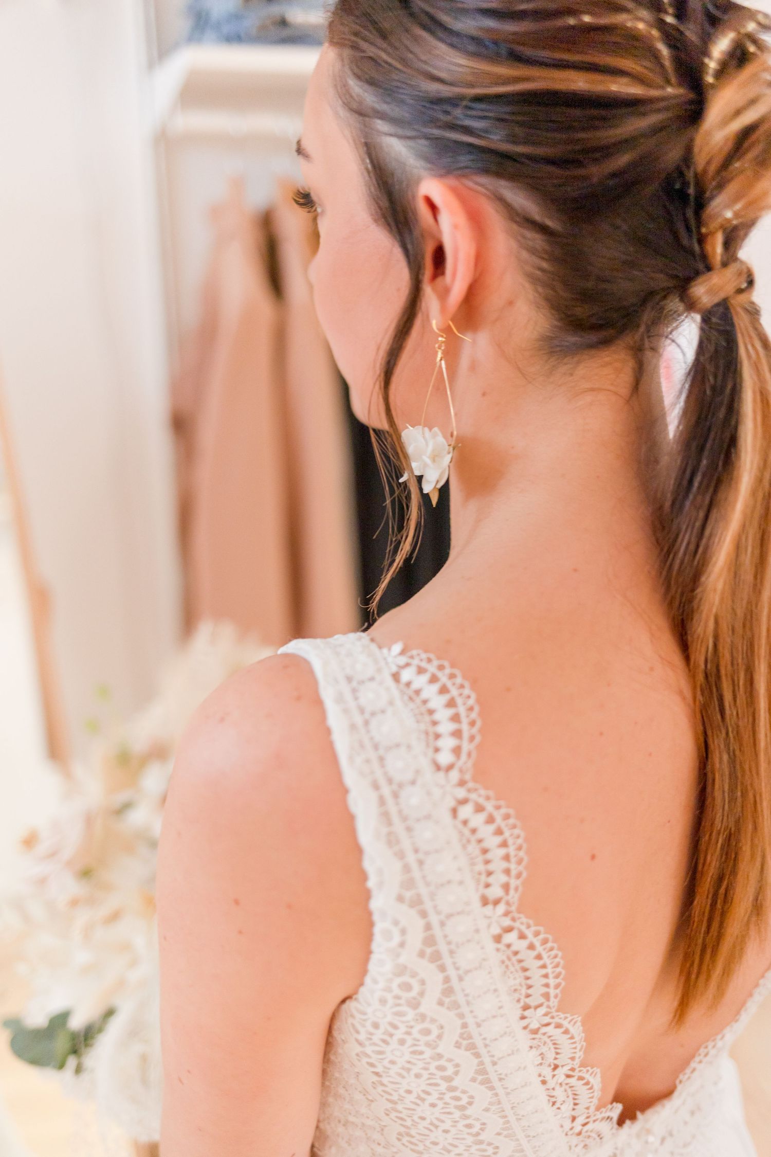 Detailed close-up of intricate lace detailing on a white wedding dress back.