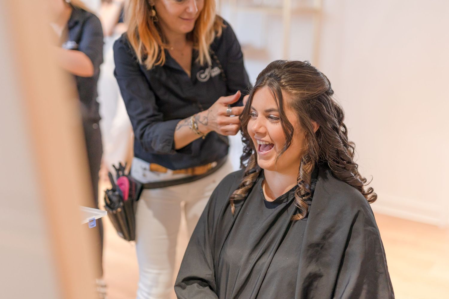 A joyful moment captured during a hair styling session in a bright salon.