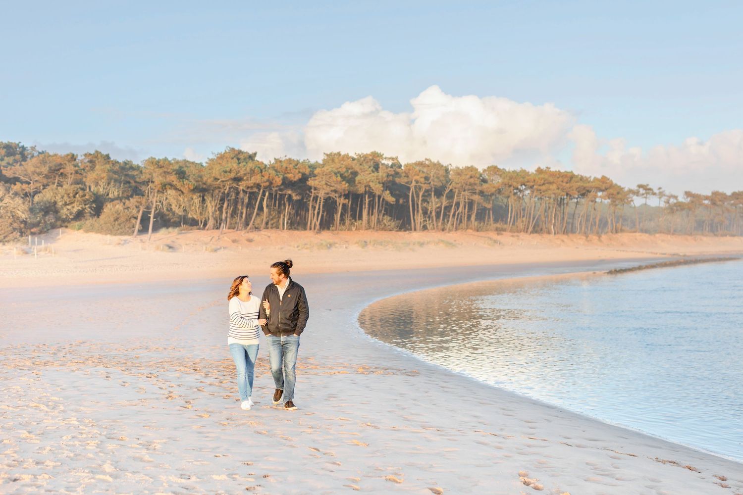 Wide beach landscape with sand dunes and ocean views at dusk.
