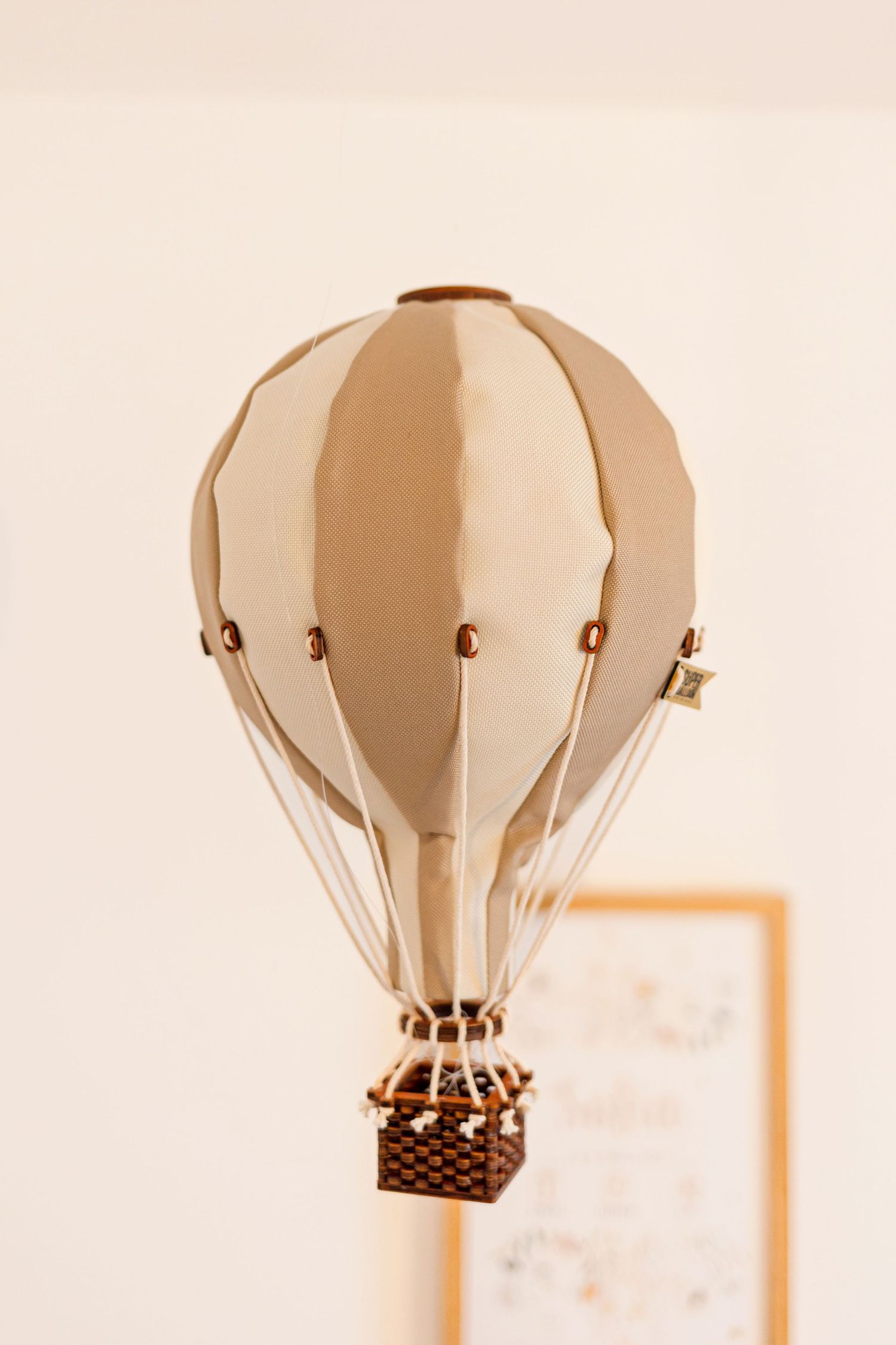 Decorative beige hot air balloon ornament in a nursery setting.