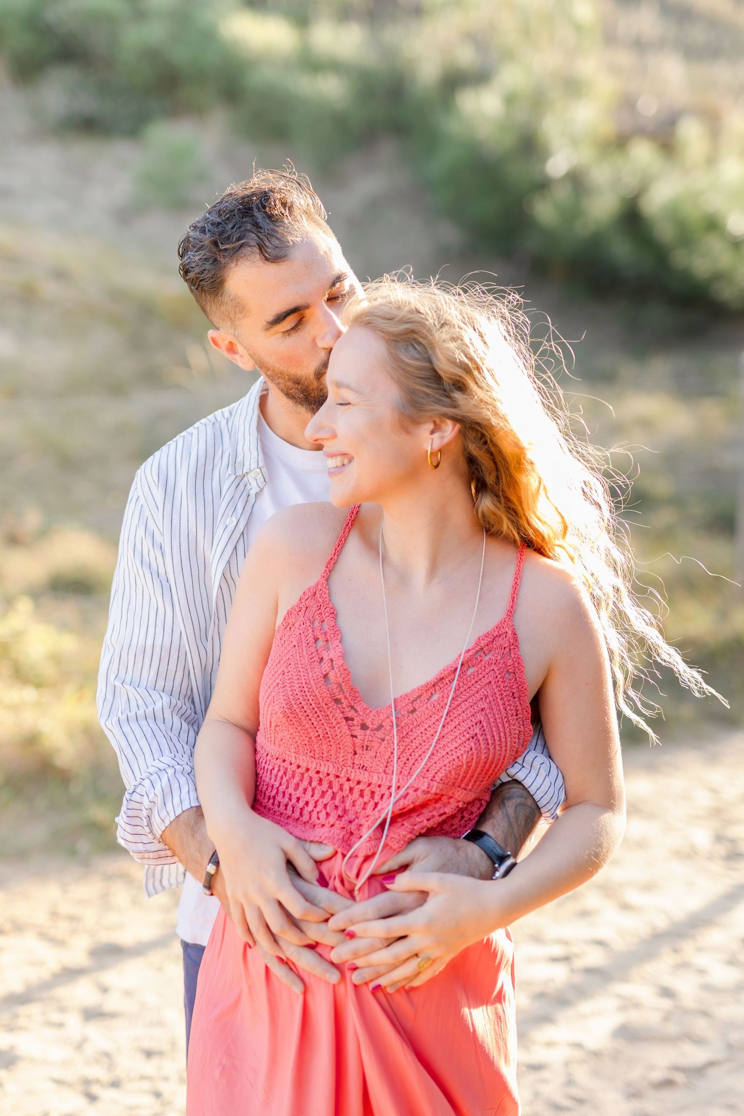 Sweet embrace captured during sunset maternity photography session in nature.