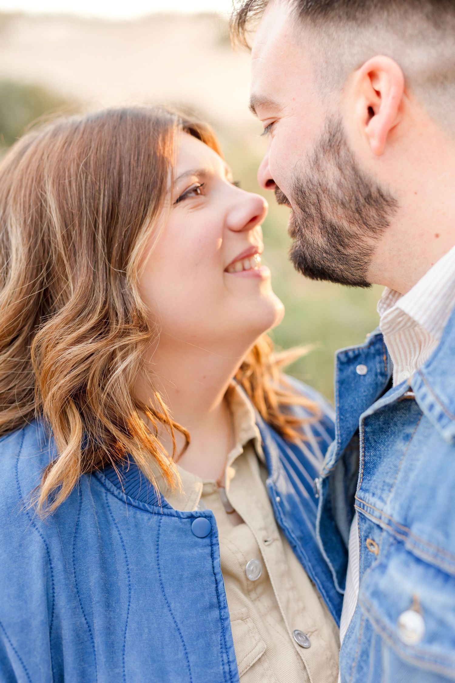 Intimate close-up of couple sharing romantic moment in warm sunset light.