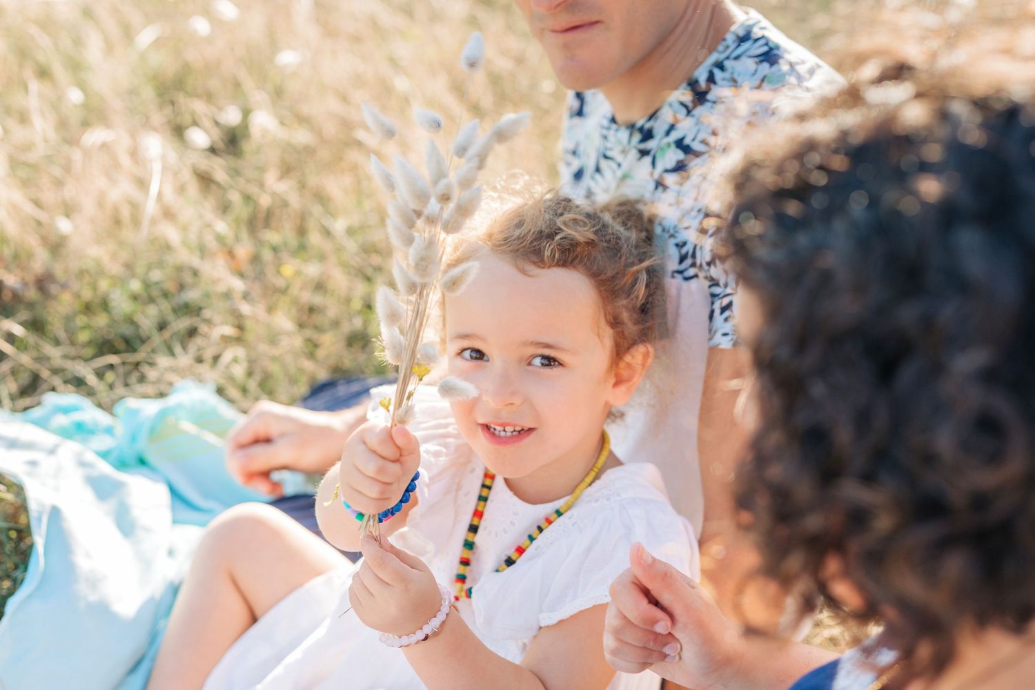 Candid family moment outdoors with soft bokeh effect in natural setting.