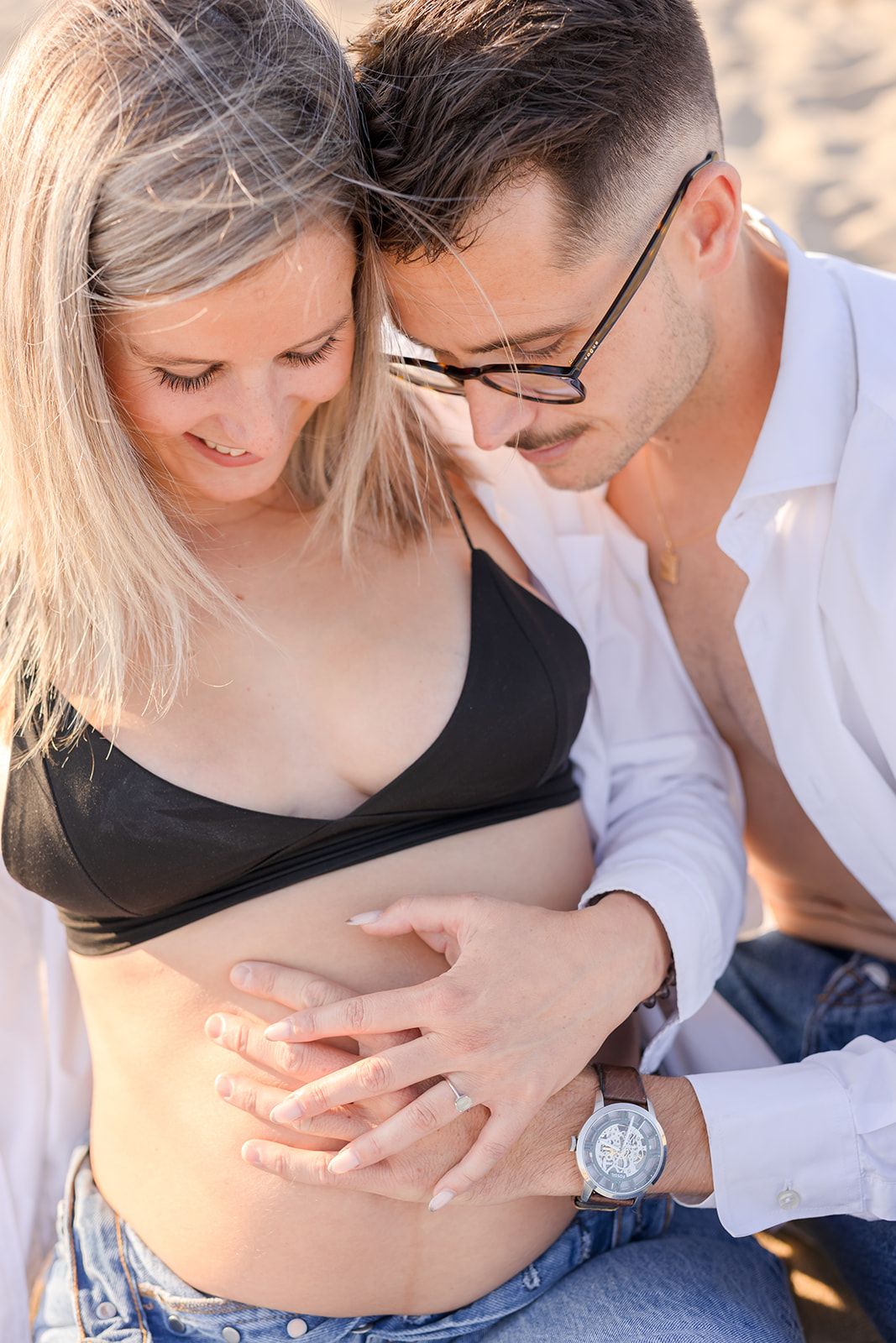 Intimate moment captured in a series of romantic maternity photos showing a couple in black and white attire outdoors.